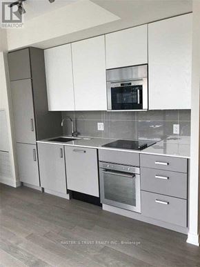 Toronto (Church-Yonge Corridor) condo for rent - A kitchen with white cabinets and a microwave above the stove.