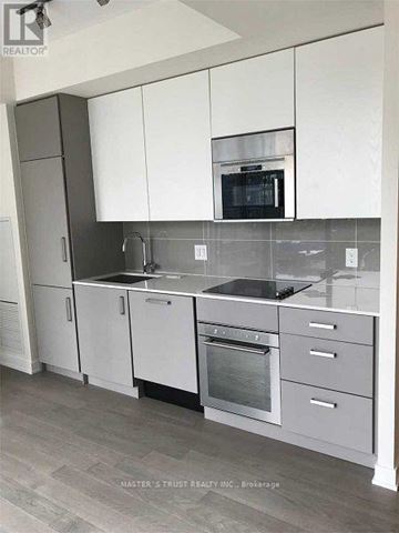 Toronto (Church-Yonge Corridor) condo for rent - A kitchen with white cabinets and a microwave above the stove.