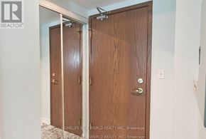 Toronto (Woburn) condo for rent - Closet doors in a room with a brokerage sign on the wall.
