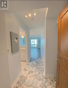 Toronto (Woburn) condo for rent - A hallway with a marble floor and a wooden door.