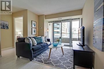 Toronto (Niagara) condo for rent - A living room with a black couch and a television.