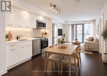Toronto (Waterfront Communities) condo for rent - A modern kitchen with white cabinets and a wooden dining table.