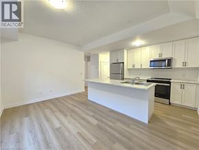 Waterdown townhouse for rent - A kitchen with white cabinets and a wooden floor.