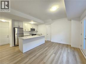 Waterdown townhouse for rent - A kitchen with white cabinets and a white island with a microwave on top.