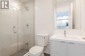 Toronto (Mount Pleasant West) condo for rent - A white toilet in a bathroom with a glass shower door.