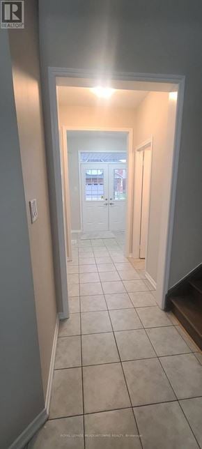 Brantford apartment for rent - A hallway with a white door and tiled floor.
