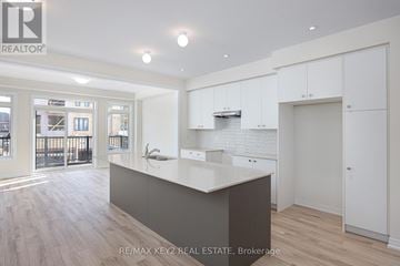 Pickering townhouse for rent - A spacious kitchen with white cabinets and a large island.