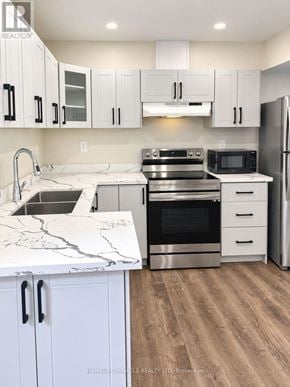 Brampton (Northwest Brampton) apartment for rent - A kitchen with white cabinets and a marble countertop.