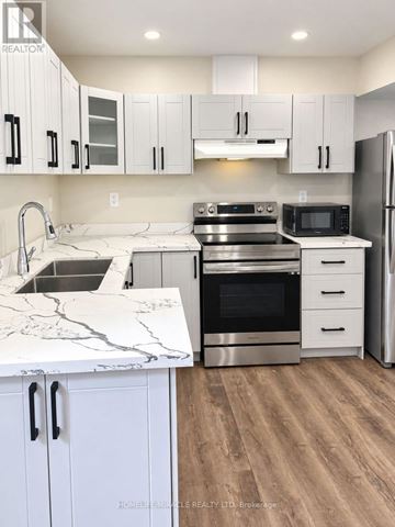 Brampton (Northwest Brampton) apartment for rent - A kitchen with white cabinets and a marble countertop.