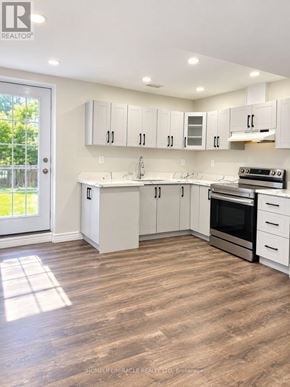 Brampton (Northwest Brampton) apartment for rent - A well-lit kitchen with white cabinets and a wooden floor.