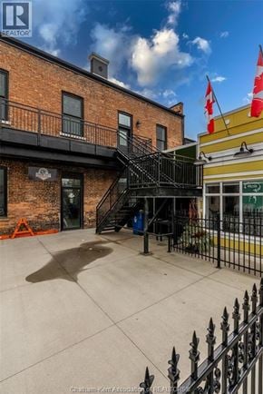 Chatham apartment for rent - A building with a black iron fence and a Canadian flag on top.