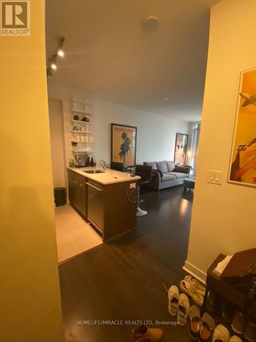 Toronto (Waterfront Communities) condo for rent - A living room with a couch, a table, and a painting on the wall.