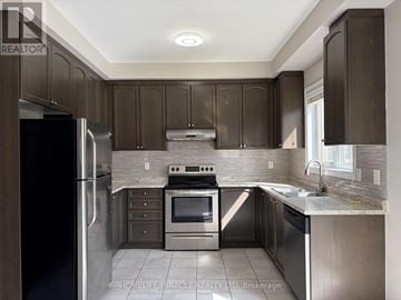 Brampton (Credit Valley) apartment for rent - A kitchen with dark brown cabinets and stainless steel appliances.