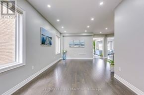 Hamilton (Waterdown) apartment for rent - A spacious room with wooden floors and a painting on the wall.
