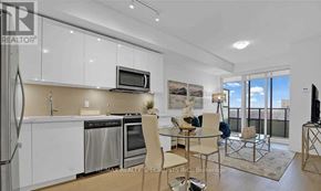 Toronto (Mimico) condo for rent - A modern kitchen with white cabinets and a glass table.