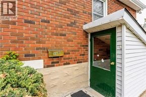 Cambridge apartment for rent - A green door is on the right side of a brick house.