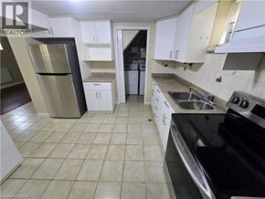 Cambridge apartment for rent - A kitchen with white cabinets and black appliances.