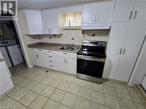Cambridge apartment for rent - A kitchen with white cabinets and a black stove top oven.