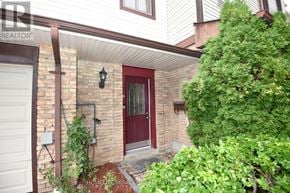 Pickering (Liverpool) townhouse for rent - A red door is on a white house with a small porch.