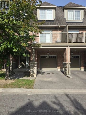 Brampton (Bram East) townhouse for rent - A building with a balcony and a tree in front of it.