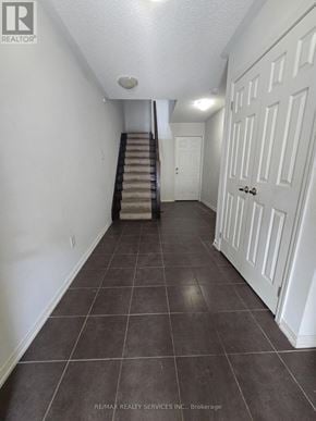 Brampton (Bram East) townhouse for rent - A hallway with a staircase and white doors.