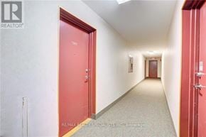 Kitchener condo for rent - A hallway with a red door on the left and a white door on the right.