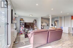 Kitchener condo for rent - A living room with a pink couch and a bookshelf filled with books.