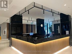 Oshawa (Windfields) condo for rent - A reception area with a black and gold reception desk.