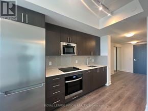 Oshawa (Windfields) condo for rent - A modern kitchen with dark wood cabinets and stainless steel appliances.