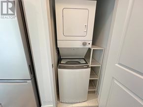 Vaughan (Concord) condo for rent - A white washing machine is in a small laundry room.