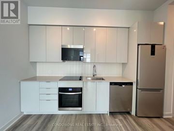 Vaughan (Concord) condo for rent - A kitchen with white cabinets and stainless steel appliances.
