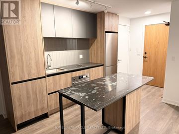 Vaughan (Beverley Glen) condo for rent - A kitchen with a table and cabinets.