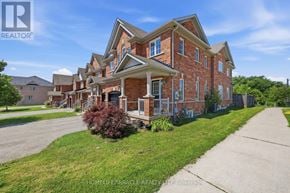 Hamilton (Waterdown) townhouse for rent - A large brick house with a well-maintained lawn in front.
