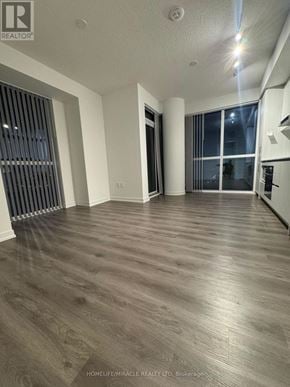 Vaughan (Vaughan Corporate Centre) condo for rent - A spacious room with wooden flooring and a large window with blinds.