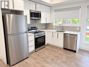 Niagara Falls (Oldfield) townhouse for rent - A kitchen with a refrigerator, oven, microwave, and sink.
