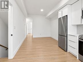 Niagara Falls (Oldfield) townhouse for rent - A kitchen with white cabinets and a stainless steel refrigerator.