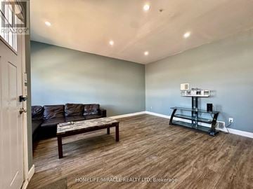 Welland (Welland Downtown) apartment for rent - A living room with a couch, coffee table, and a television.