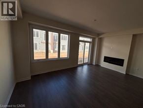 Erin townhouse for rent - A large empty room with a fireplace and a view of a building outside the window.