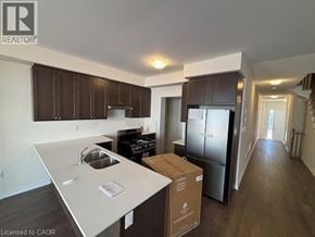 Erin townhouse for rent - A kitchen with a white counter top and brown cabinets.