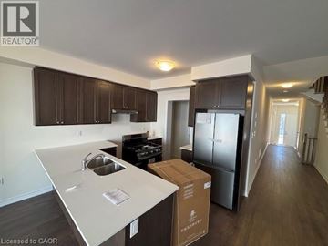 Erin townhouse for rent - A kitchen with a white counter top and brown cabinets.