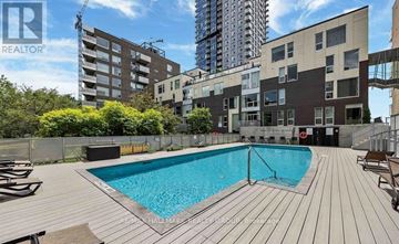 Ottawa condo for rent - A pool in a backyard surrounded by wooden decking.