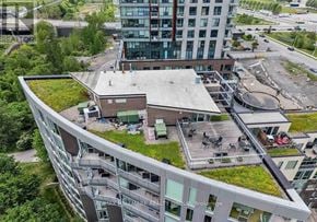 Ottawa condo for rent - A modern building with a green roof and a parking lot in front.