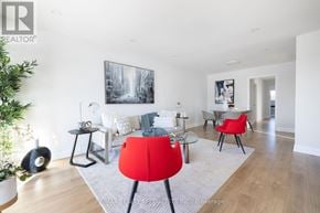 Mississauga (Rathwood) apartment for rent - A living room with a red chair and a painting on the wall.