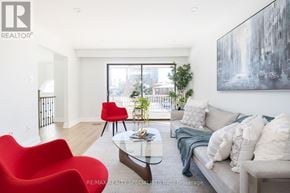Mississauga (Rathwood) apartment for rent - A living room with a red chair and a glass table.
