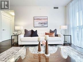 Toronto (Annex) condo for rent - A well-lit living room with a white couch and a painting on the wall.