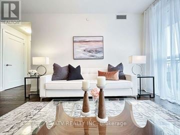 Toronto (Annex) condo for rent - A well-lit living room with a white couch and a painting on the wall.
