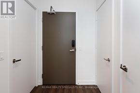 Mississauga (City Centre) condo for rent - A closed brown door with a handle and a small black device on the door.