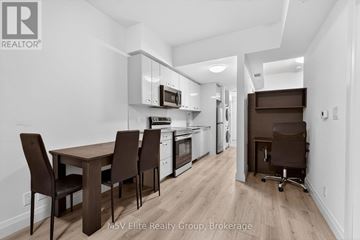 Kingston (Central City East) condo for rent - A kitchen with brown chairs and a wooden table.