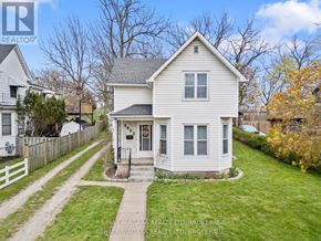 Niagara Falls (Dorchester) apartment for rent - A white house with a grey roof is surrounded by a green lawn and a white picket fence.