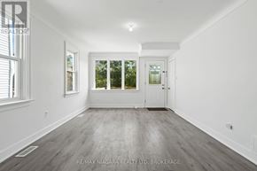 St. Catharines (E. Chester) apartment for rent - A spacious room with a door, windows, and a wooden floor.